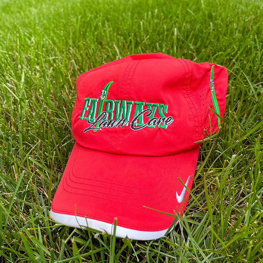 Fairways Lawn Care branded hat resting on a lush green lawn in Downingtown PA.